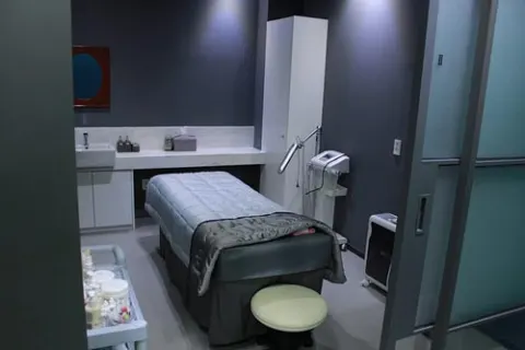 Single-patient procedure room with a treatment couch and instrument trolley